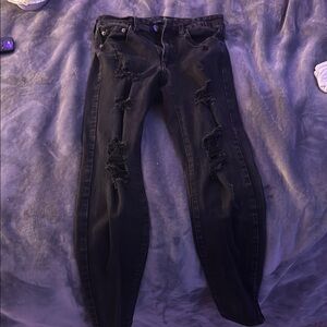 Black Skinny high waisted jeans with rips at the knee and thigh.